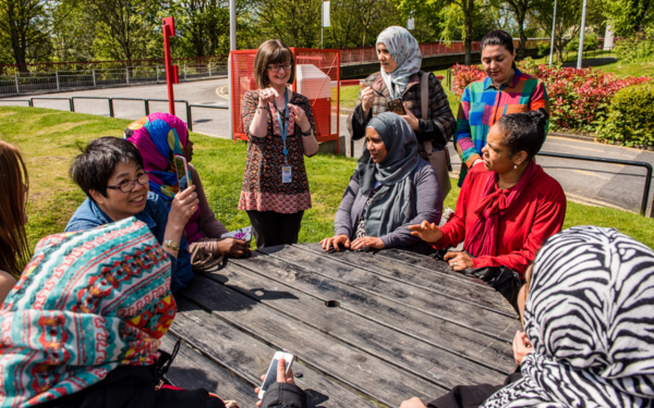 Group of people sat around a table outside