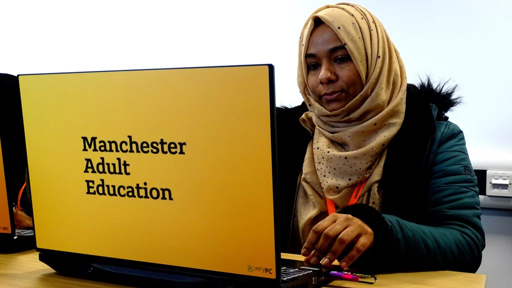 Person sat in a classroom with a Manchester Adult Education laptop