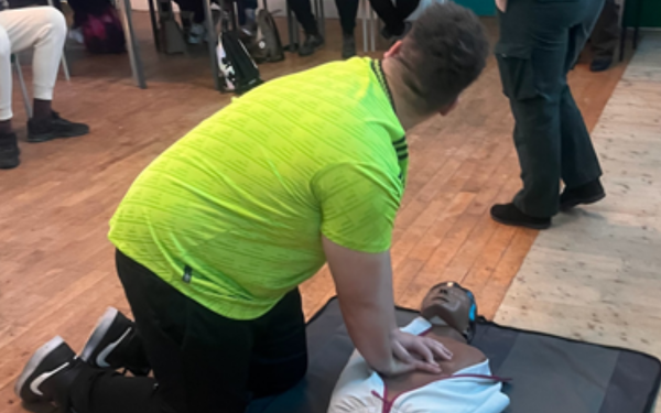 Person practicing CPR compressions on a doll