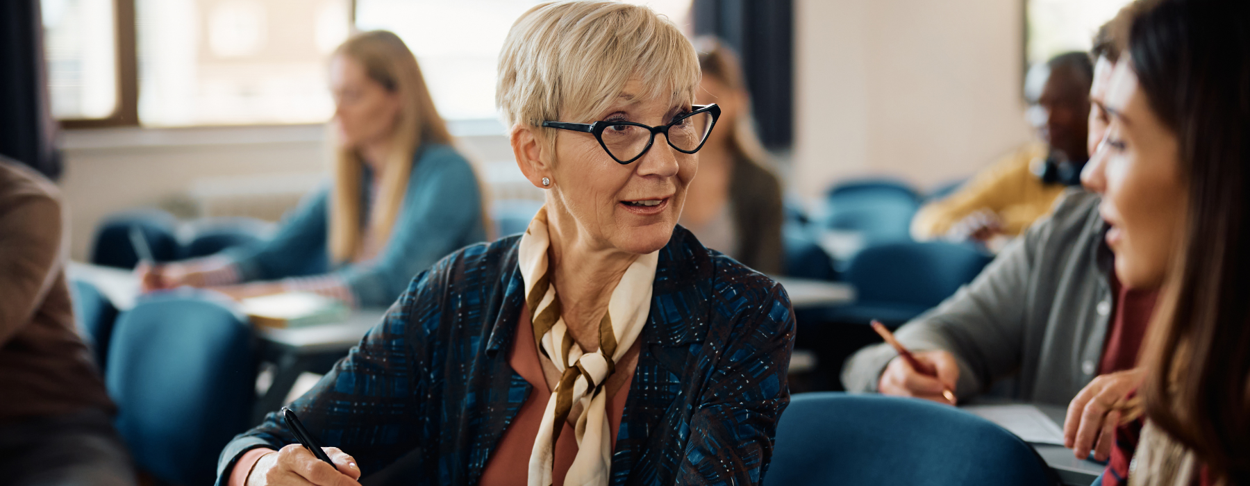 Person sat in a classroom talking to another learner