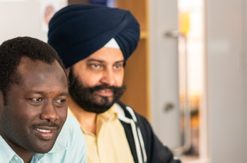 Two men sitting together looking away at something.