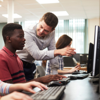 Person teaching college students in a computer classroom